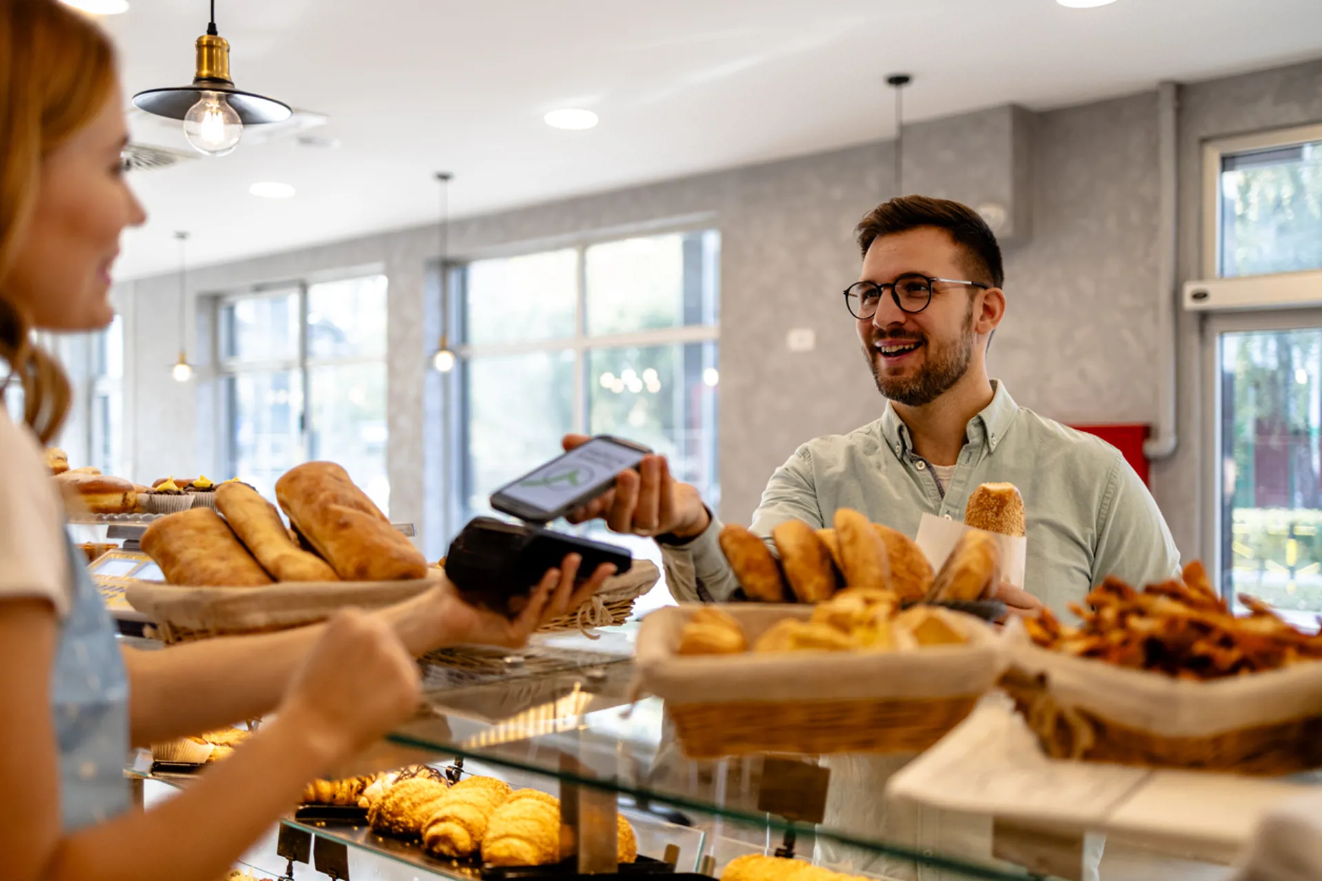 Man using mobile pay at a bakery