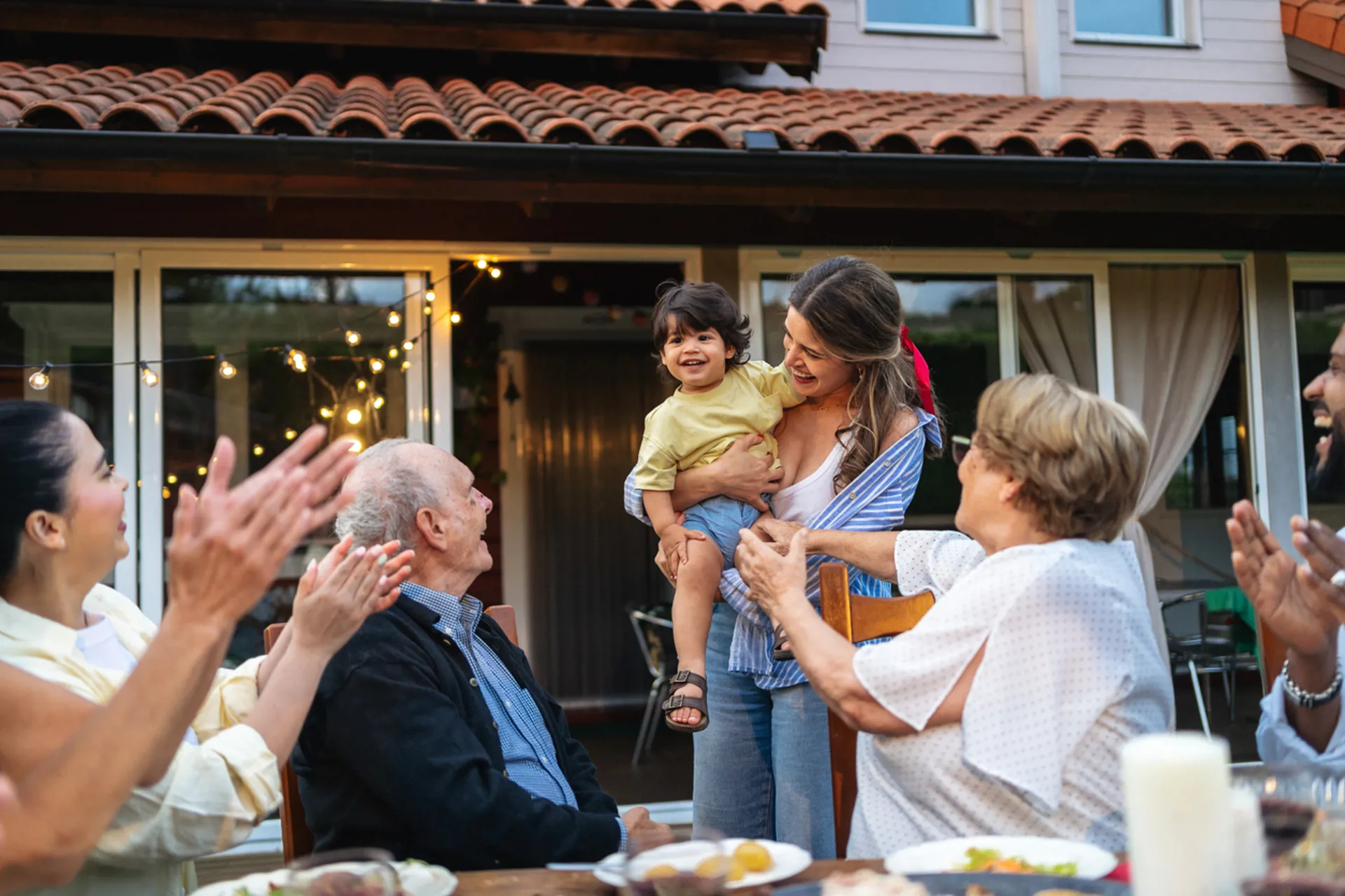 Big family celebrating a baby during a lively garden party