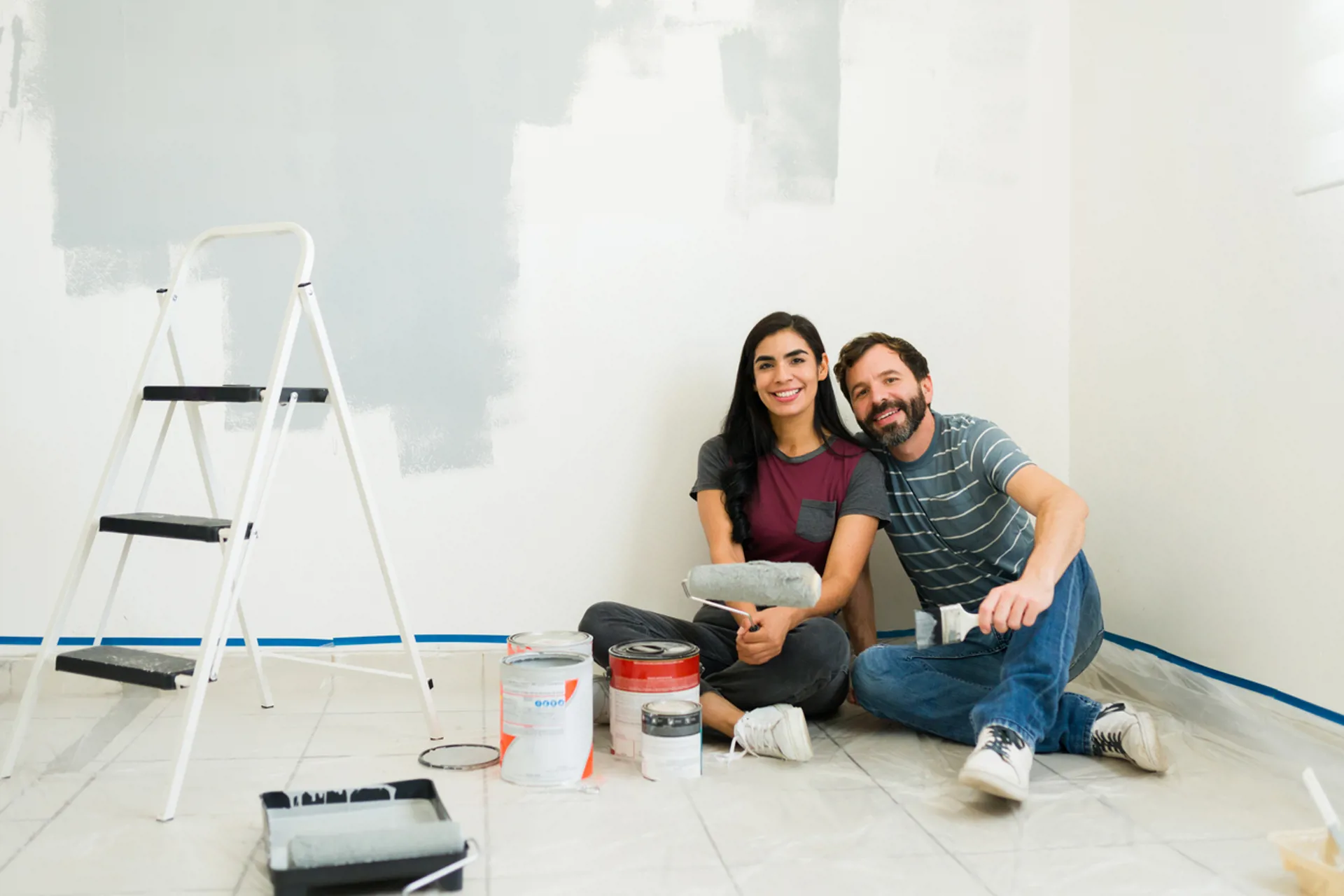 Couple taking a break from painting their house