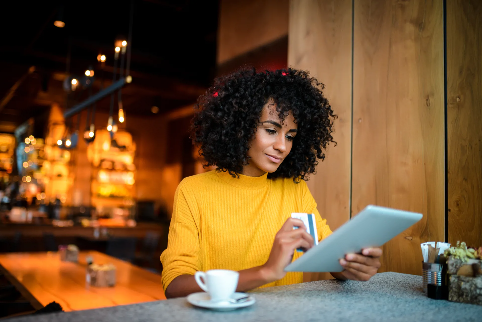 Woman holding tablet and bank card