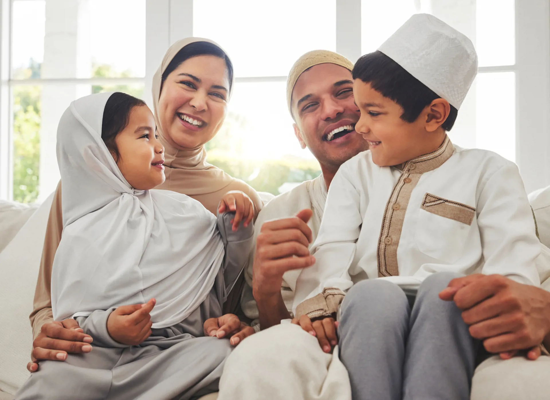 Happy family, Islam and laughing on couch for Eid