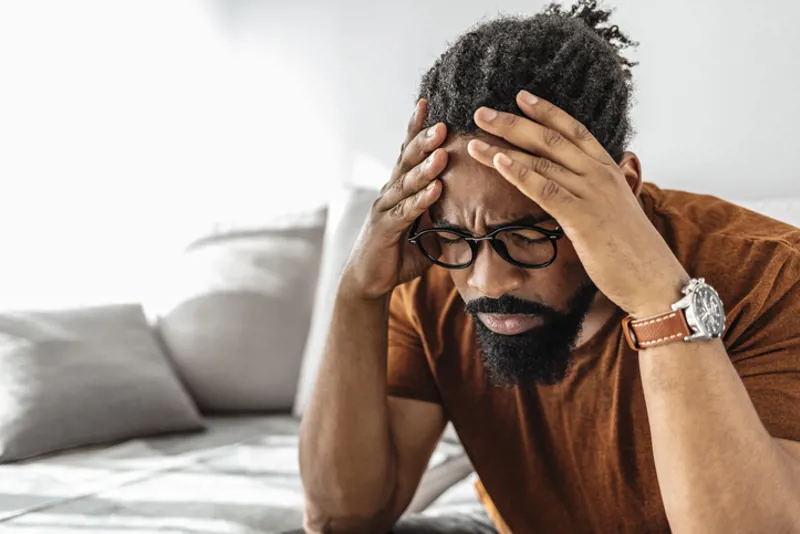 Man looking concerned with both hands on his head