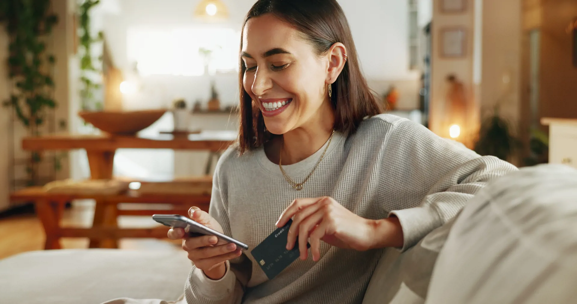 Woman smiling holding card and phone