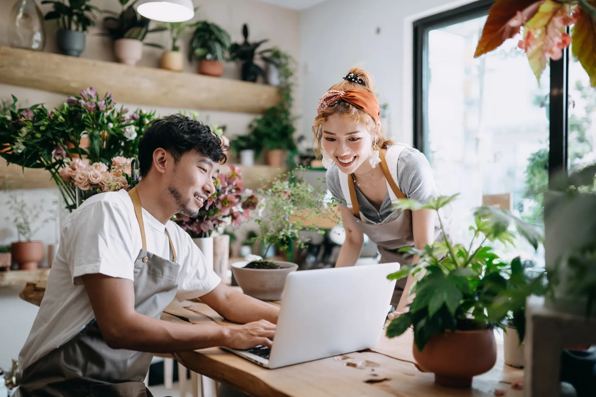 couple in florist shop looking at laptop