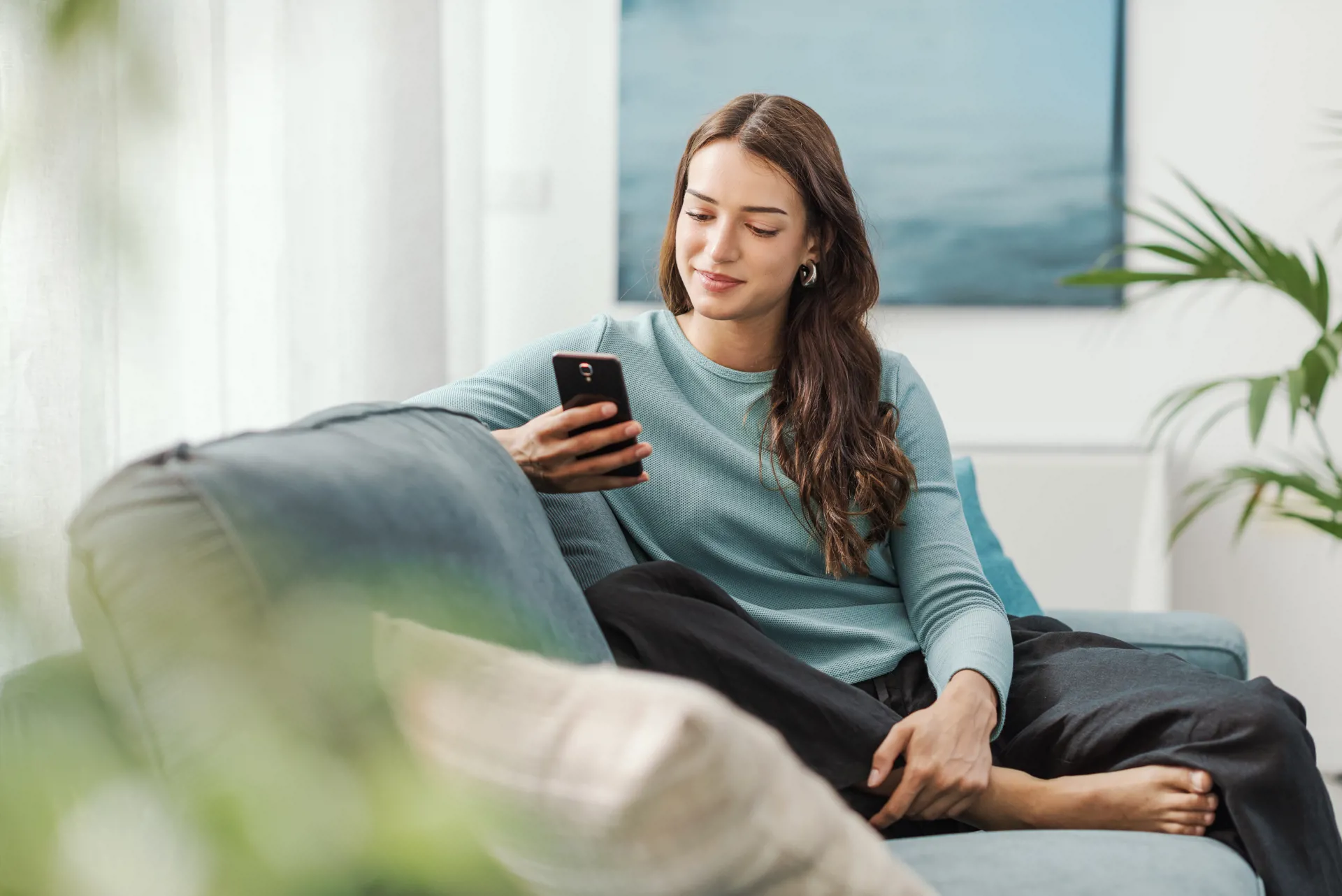 Woman on couch looking at mobile phone