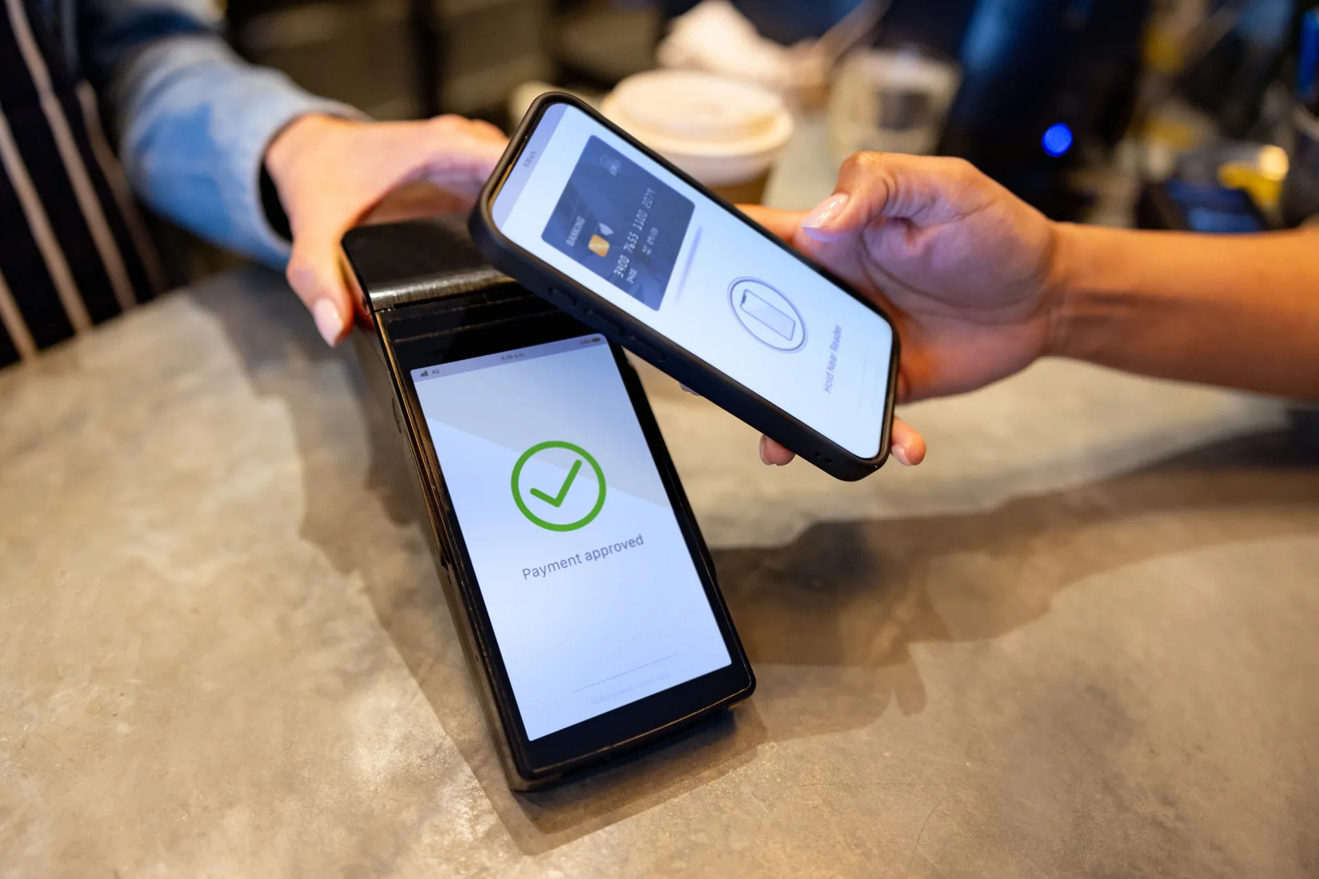 Image of person tapping their phone to complete digital payment