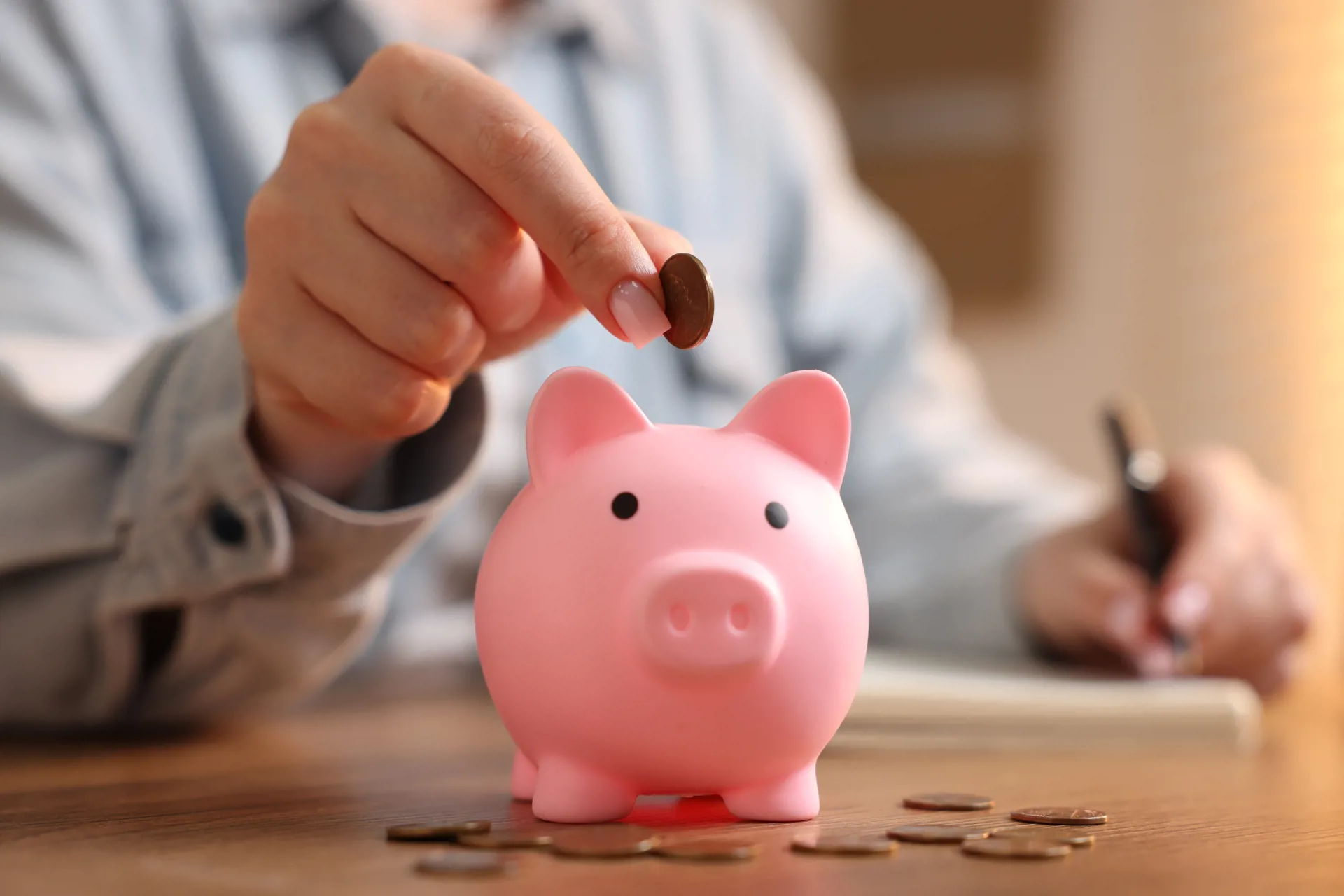 hand putting coin in piggy bank