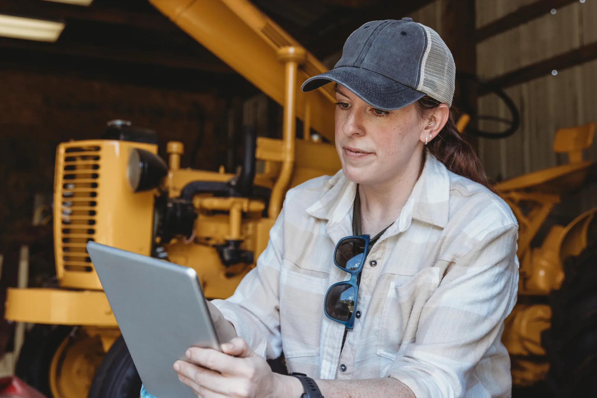 woman in baseball cap holding tablet