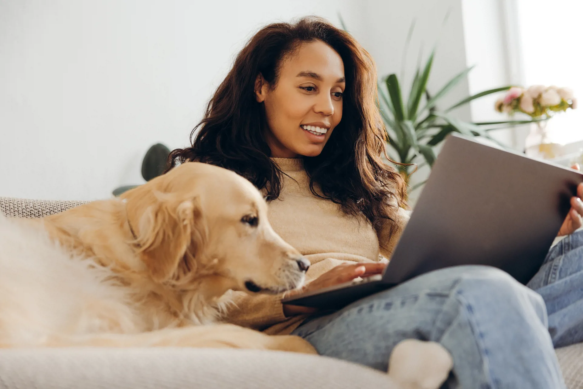 Happy woman with dog looking at account perks online
