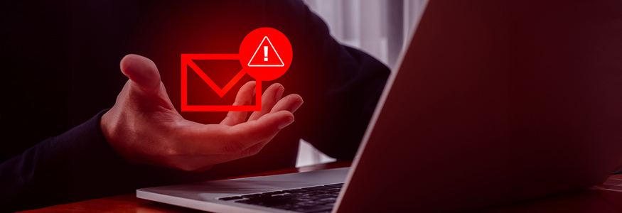 Beware of email scam - dark room man on computer with glowing red letter in his hand.